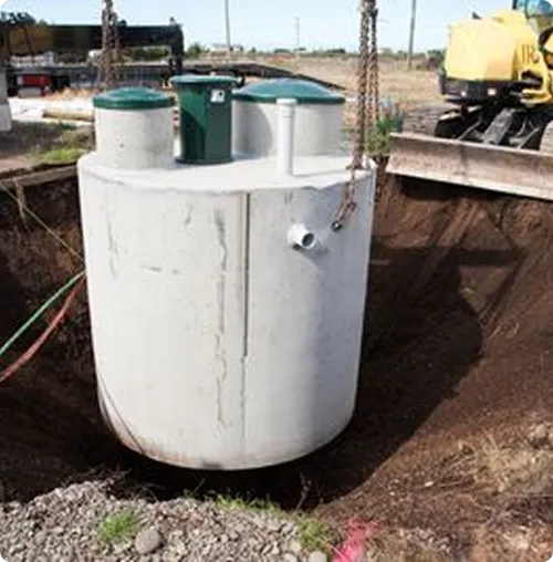 Septic tank being lowered into hole dug in the ground